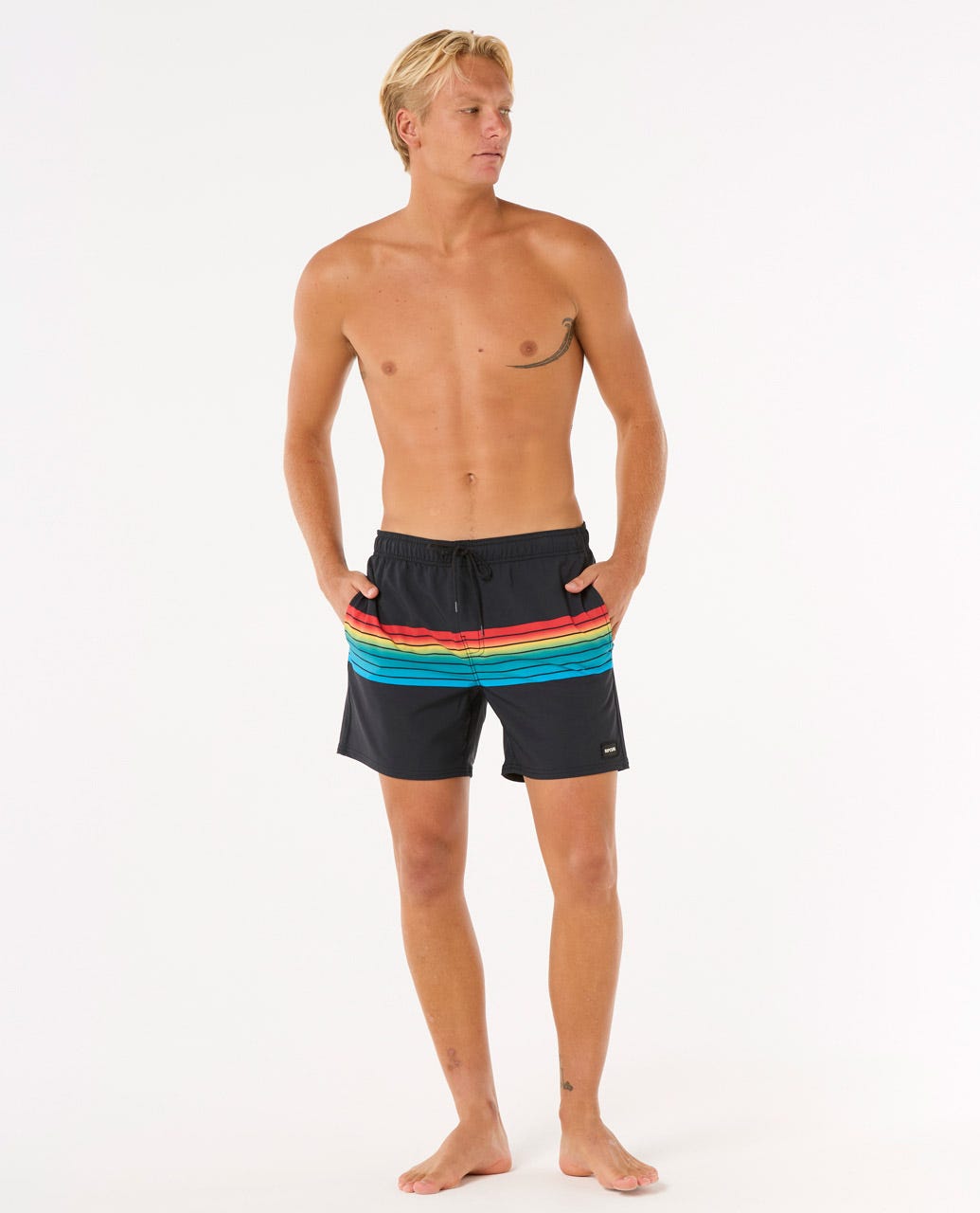 Modelo de cuerpo entero con el bañador Rip Curl Surf Revival Volley 16'', mostrando ajuste por encima de la rodilla.