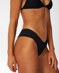 Detalle lateral de la braga Rip Curl Premium Surf Skimpy Hipster negra, tejido acanalado y ajuste hipster.