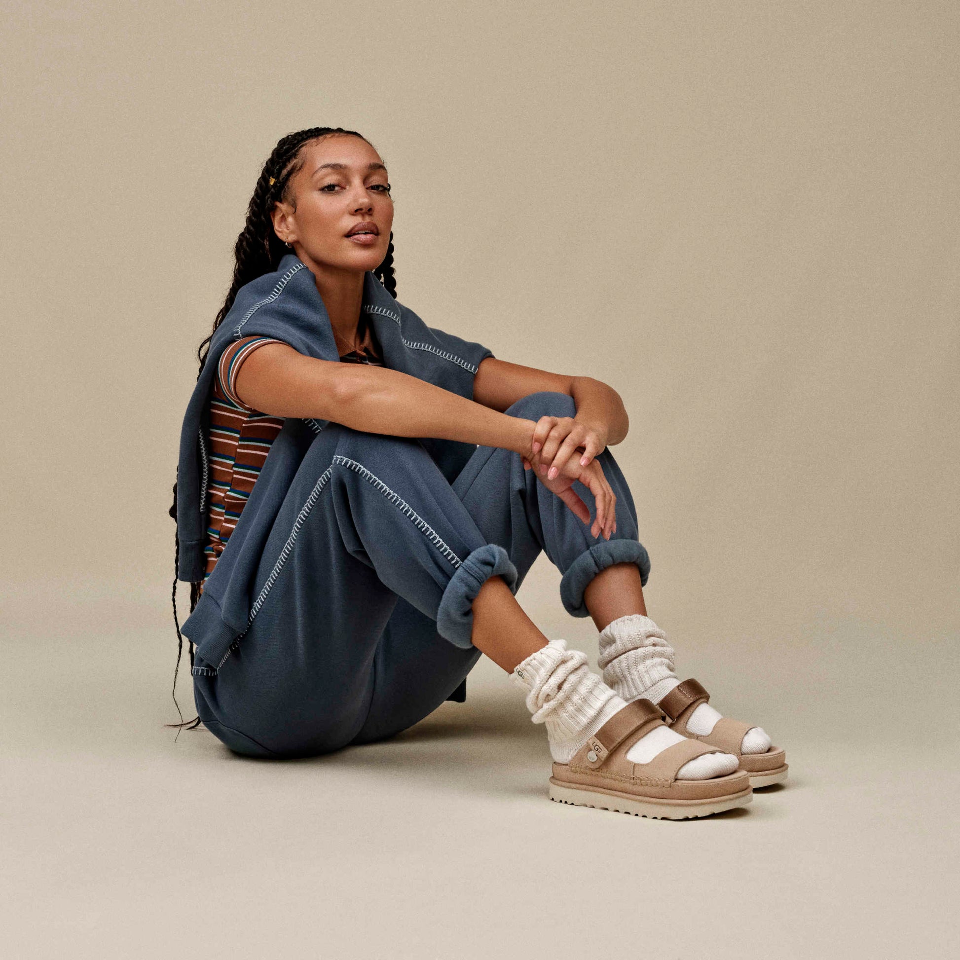 Mujer con look urbano y sandalias UGG Goldenstar Glide marrón claro, combinación con chándal azul