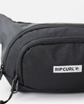 Detalle del bolsillo delantero y logotipo Rip Curl en la Riñonera Waist Bag Icons.