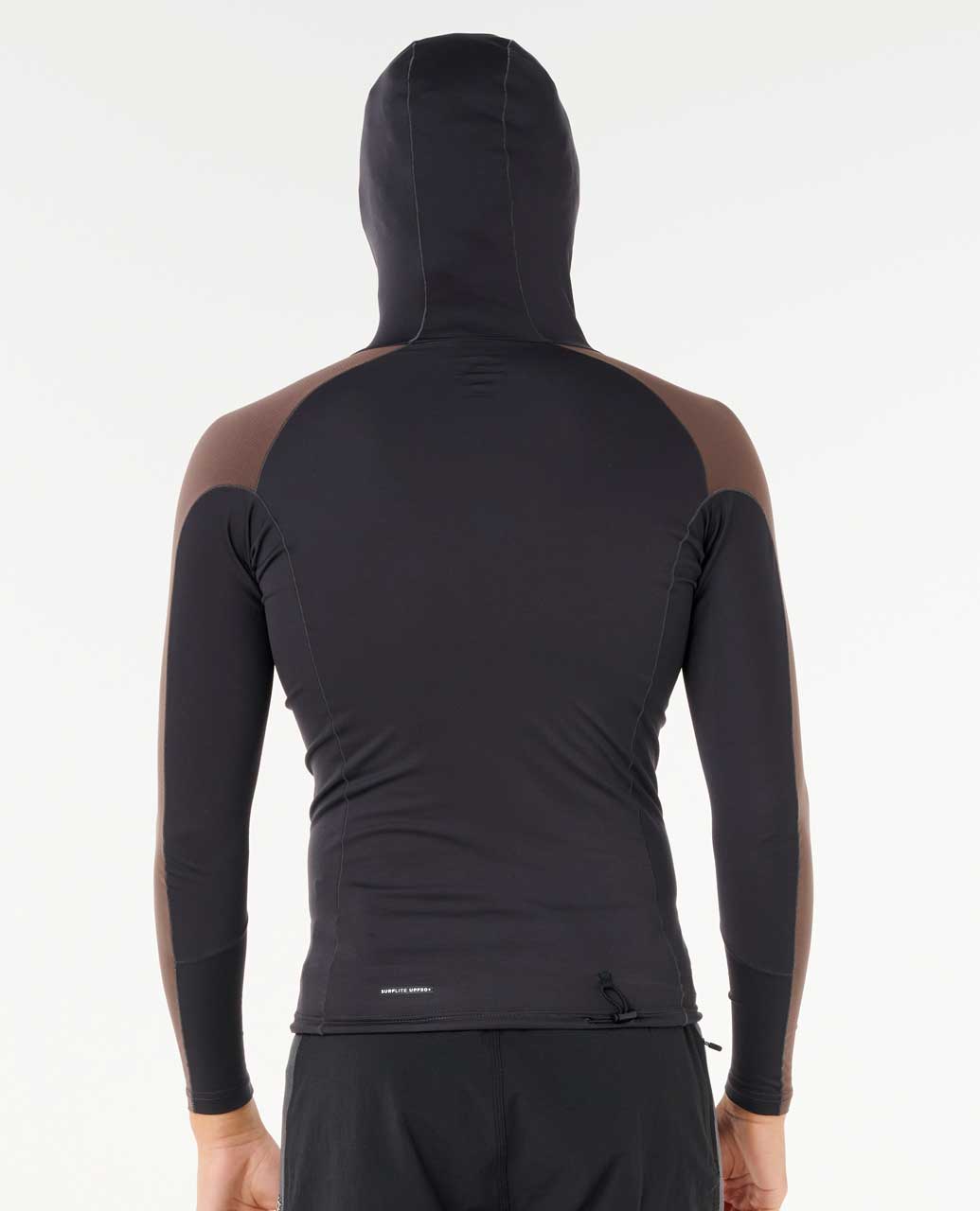 Modelo con camiseta Rip Curl Search UPF Performance L/S Hood negra y marrón, capucha puesta, protección solar UPF 50+