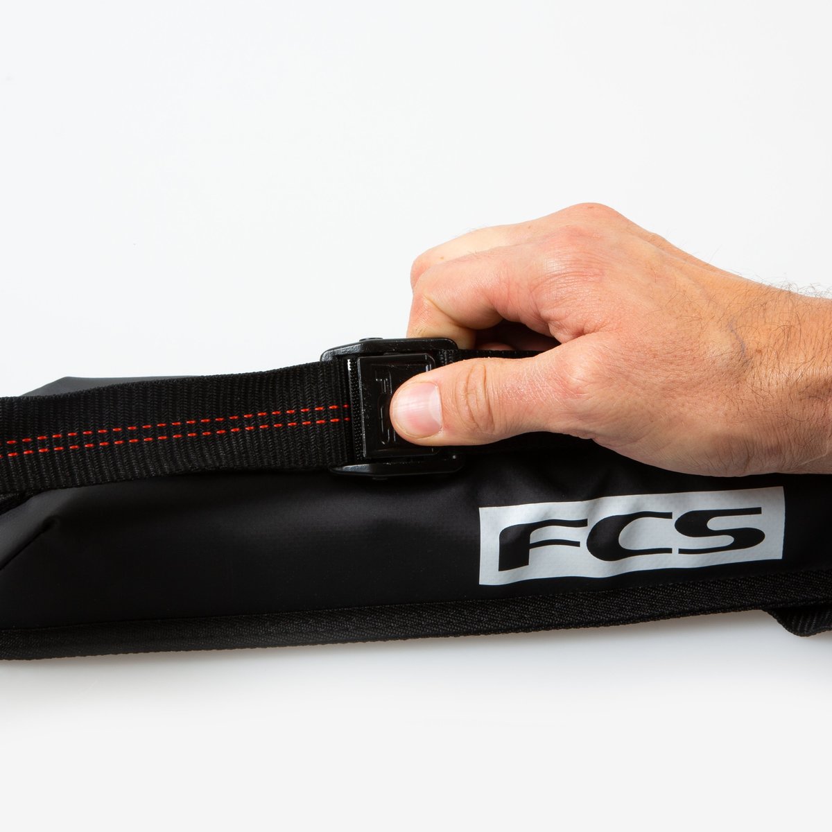 Un surfer coge la Baca para Tablas de Surf FCS Soft Rack