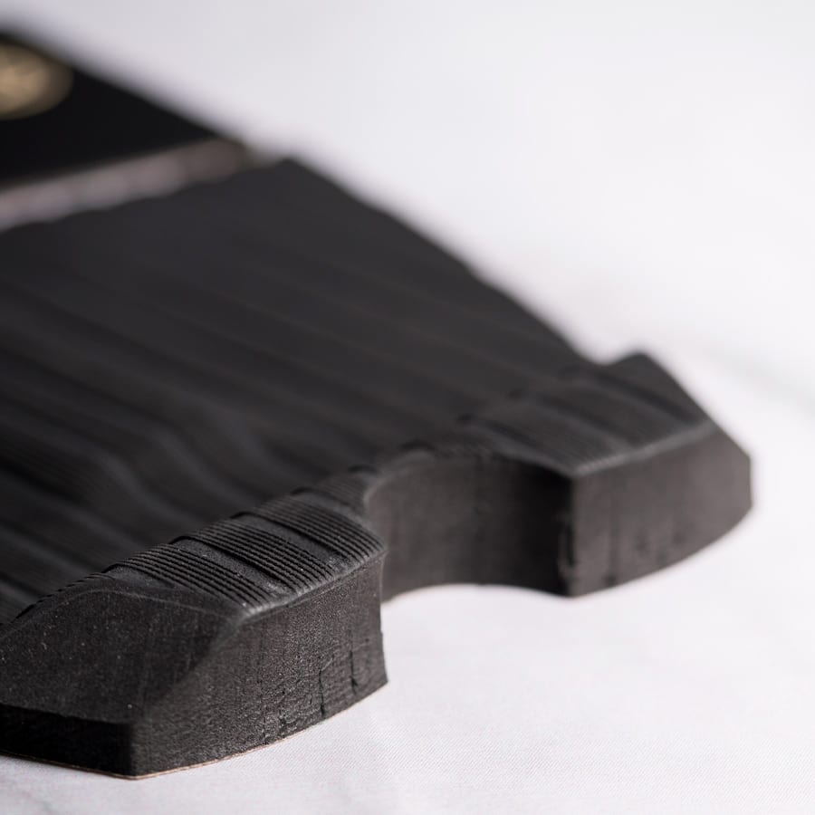 Primer plano de la pieza principal del grip Deflow Vol.2 negro mostrando el patrón de líneas para agarre diferencial bajo presión