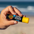 Una mano sujeta el rotector Solar en Stick Amarillo SPF 50+ de Sun Zapper