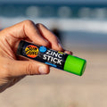 Una mano sujeta el rotector Solar en Stick Verde SPF 50+ de Sun Zapper