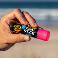 Una mano sujeta el rotector Solar en Stick Rosa SPF 50+ de Sun Zapper