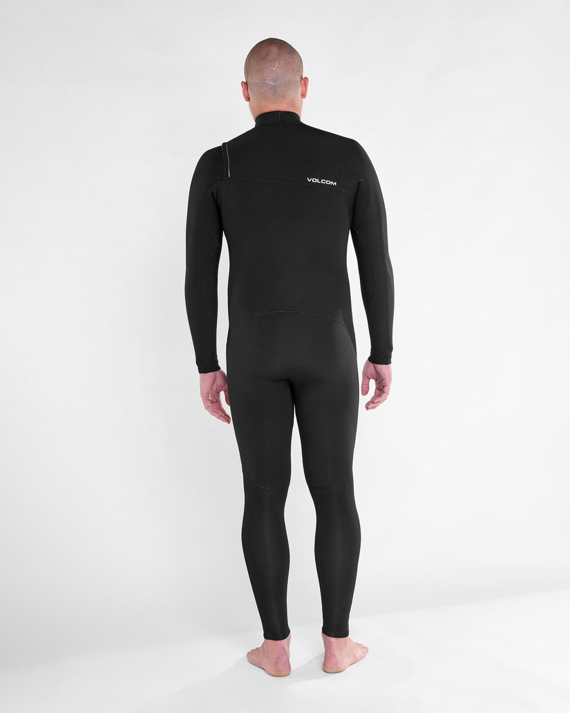 Vista trasera de modelo con el traje de neopreno VOLCOM 4/3MM Chest Zip Fullsuit en color Negro, destacando el diseño ergonómico y el logo Volcom en la parte superior.