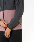 Detalle de manga y ajuste del puño de la chaqueta Rip Curl Elite Anti-Series para hombre, color gris y rosa, tejido repelente al agua