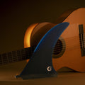 Quilla single fin Deflow Bulerías Fugue azul marino frente a guitarra flamenca, vista completa con base US Box y tornillo dorado, logo CD de Clovis Donizetti.