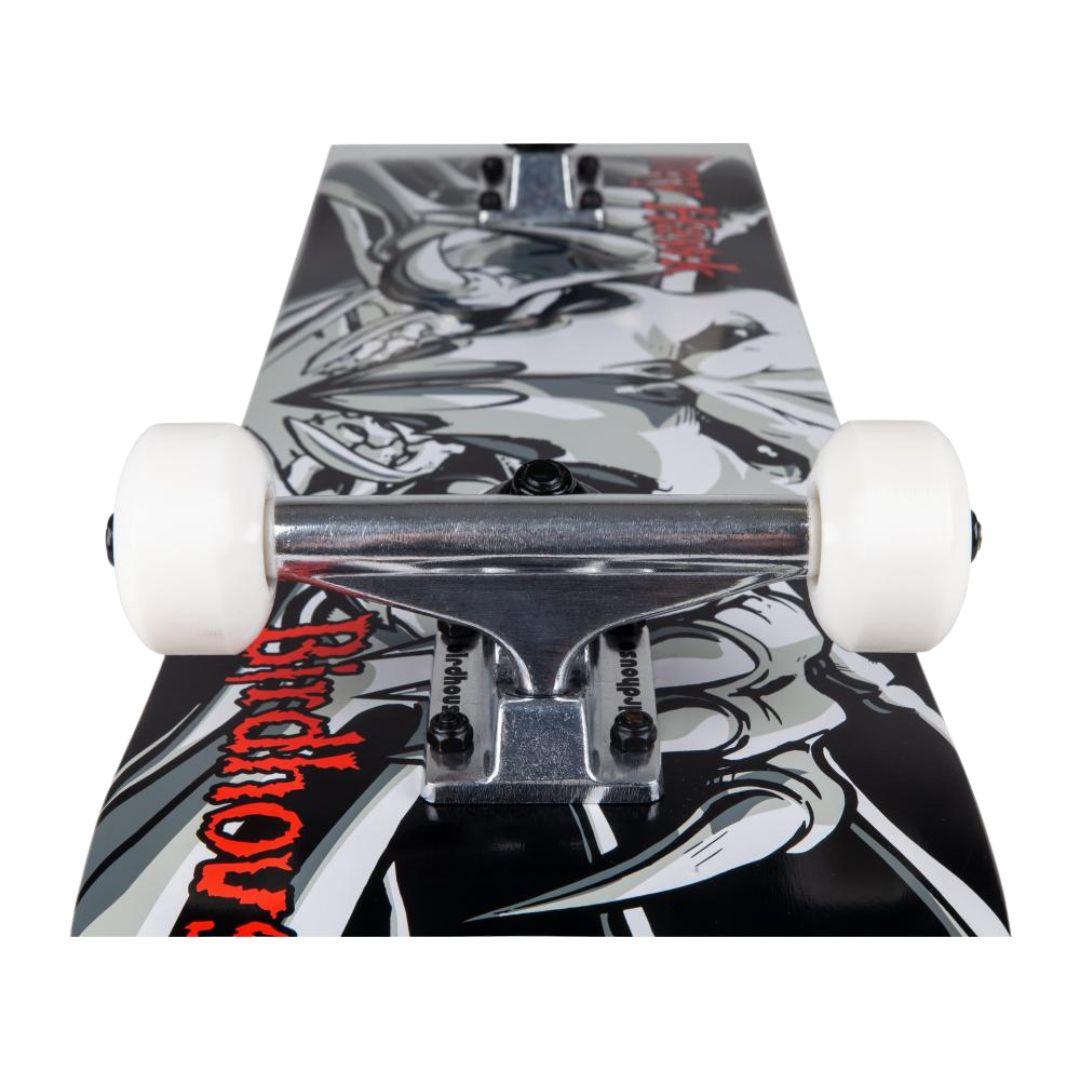 Skate completo Birdhouse Stage 1 Hawk Falcon III visto desde abajo en perspectiva: eje del truck plateado, ruedas blancas y gráfica del halcón esquelético en negro, gris y rojo.