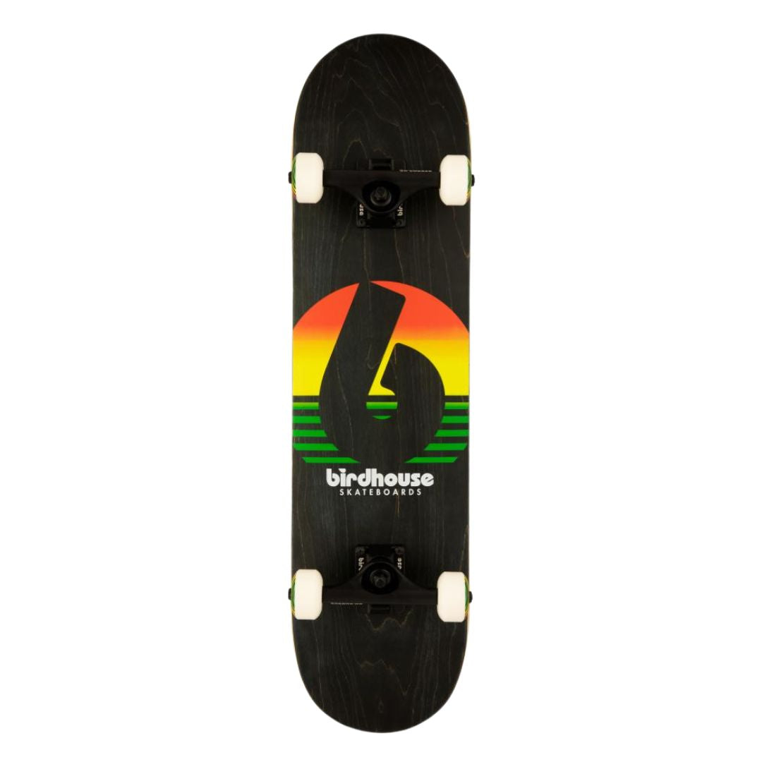 Base del skate completo Birdhouse Stage 3 Sunset con tabla negra, logo B recortado sobre un sol en degradado rojo, amarillo y verde, texto Birdhouse Skateboards, trucks negros y ruedas blancas