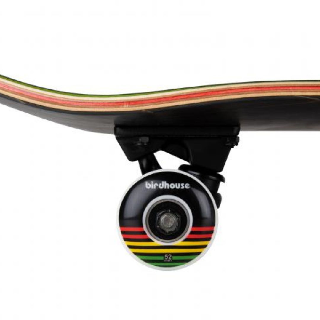 Detalle lateral de una rueda negra de 52 mm con rayas rojas, amarillas y verdes y logo Birdhouse, truck negro y capas de arce con veta roja y verde del skate Birdhouse Stage 3 Sunset