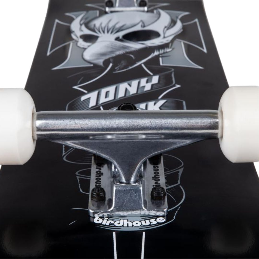 Truck plateado Logo Raw con tuercas negras y ruedas blancas sobre la gráfica negra y gris del skate completo Birdhouse Stage 1 Hawk Crest con el cartel Tony Hawk y el logo Birdhouse