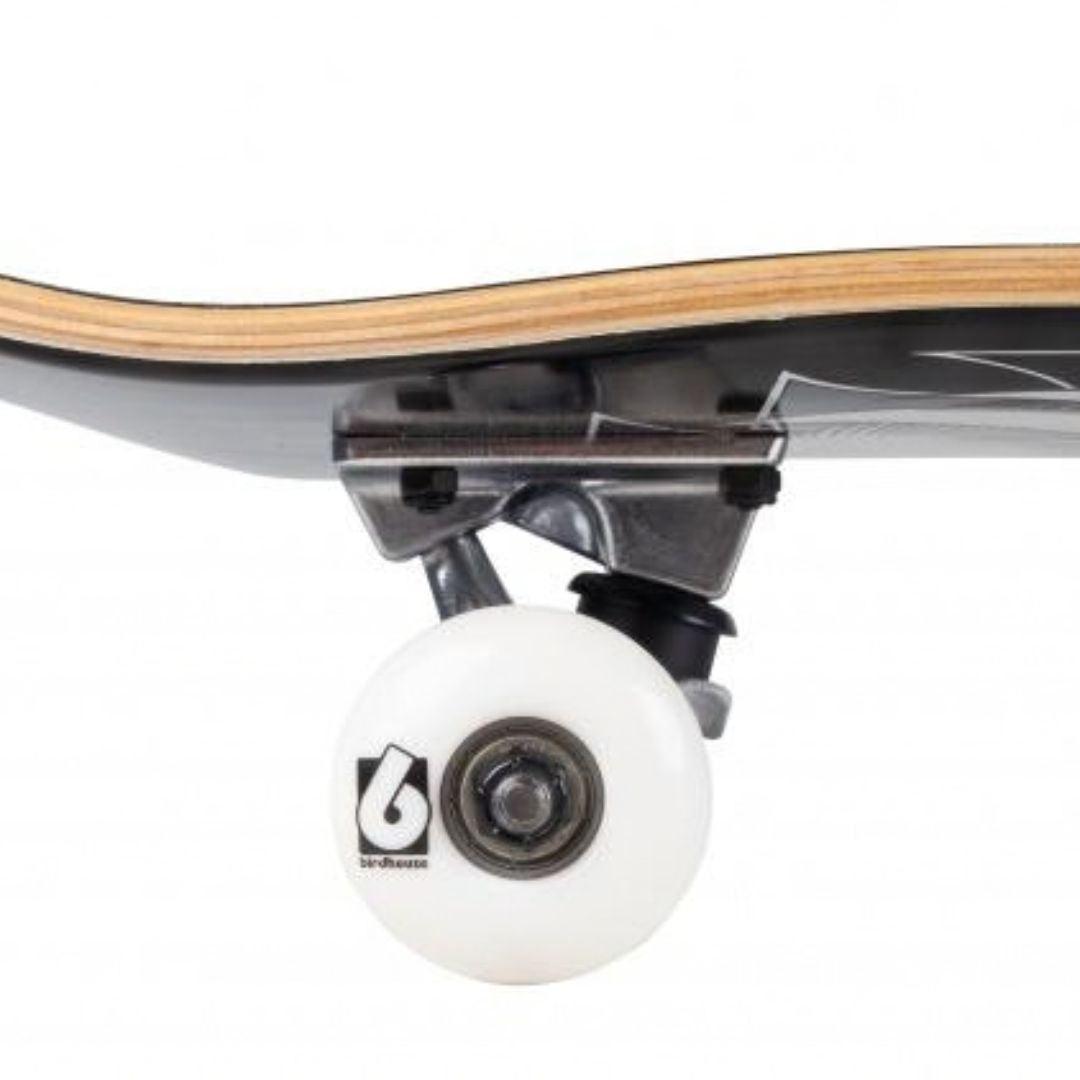 Detalle lateral de una rueda blanca con el logo Birdhouse, el truck plateado y los cantos de arce del skate completo Birdhouse Stage 1 Hawk Crest negro con gráfica gris