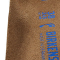 Primer plano de la superficie de ante de la plantilla Birkenstock Arizona Tobacco Brown con sello Made in Germany estampado en azul.