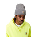 Gorro Carhartt Acrylic Watch Hat en color Grey Heather, mostrado en un modelo que lleva sudadera amarilla fluorescente.