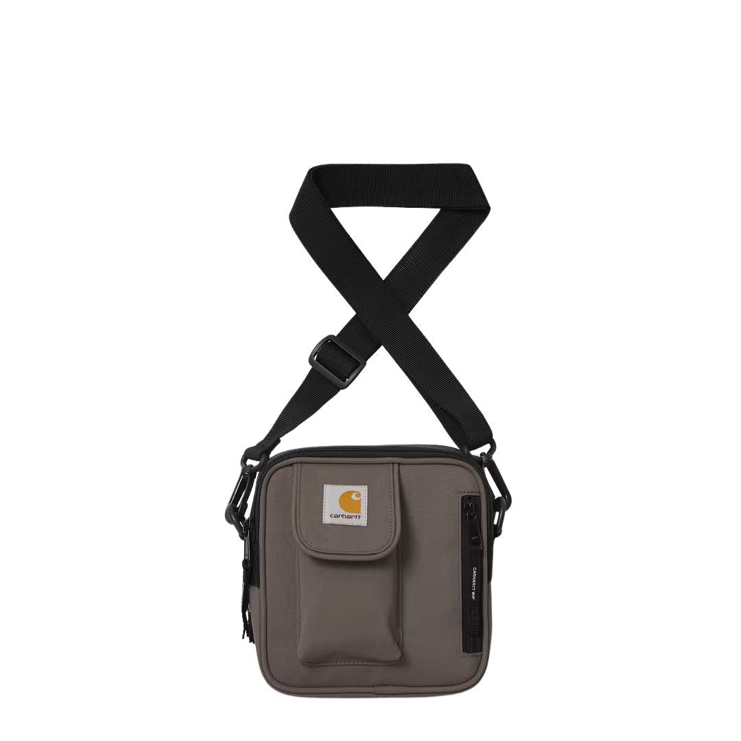 Bolso bandolera Carhartt Essentials Bag Small en color shale con correa ajustable y bolsillos frontales, vista frontal.