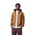 Modelo masculino vistiendo la chaqueta Carhartt WIP Active Jacket Winter Hamilton Brown abierta en posición frontal.
