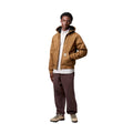 Modelo masculino vistiendo la chaqueta Carhartt WIP Active Jacket Winter Hamilton Brown abierta de frente.