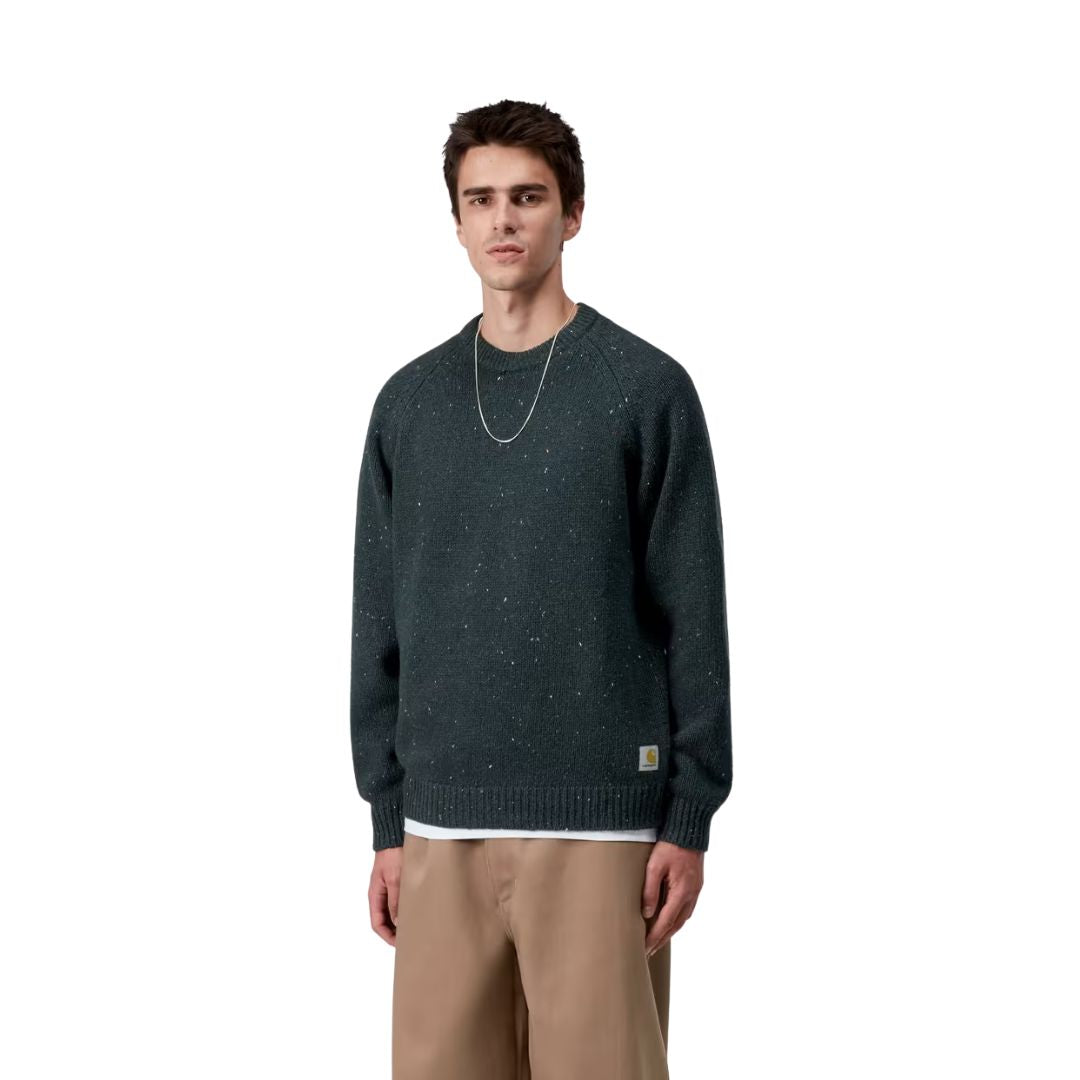Modelo masculino vistiendo el Carhartt WIP Anglistic Sweater en color Speckled Deep Lagoon, vista lateral del suéter.