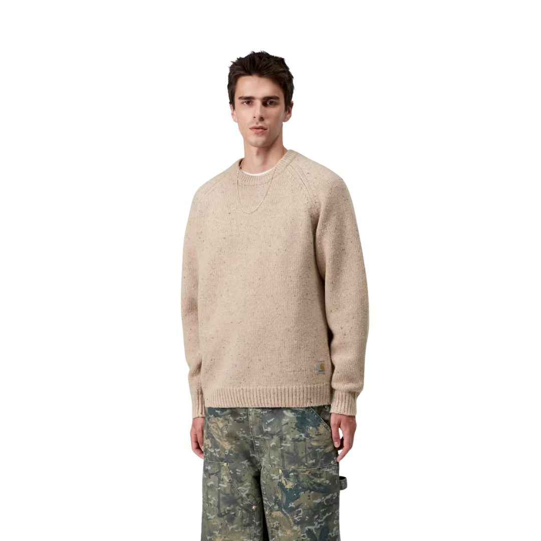 Modelo masculino vistiendo el Carhartt WIP Anglistic Sweater en color Speckled Fleur de Sel, vista lateral del suéter.