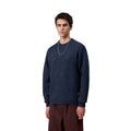 Modelo masculino vistiendo el Carhartt WIP Anglistic Sweater en color Speckled Jupiter, vista lateral del suéter.