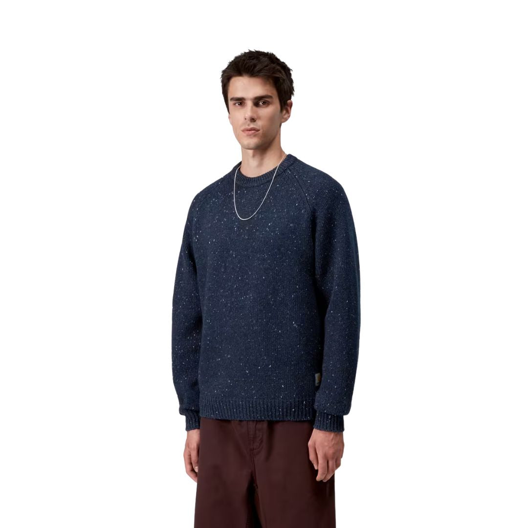 Modelo masculino vistiendo el Carhartt WIP Anglistic Sweater en color Speckled Jupiter, vista lateral del suéter.
