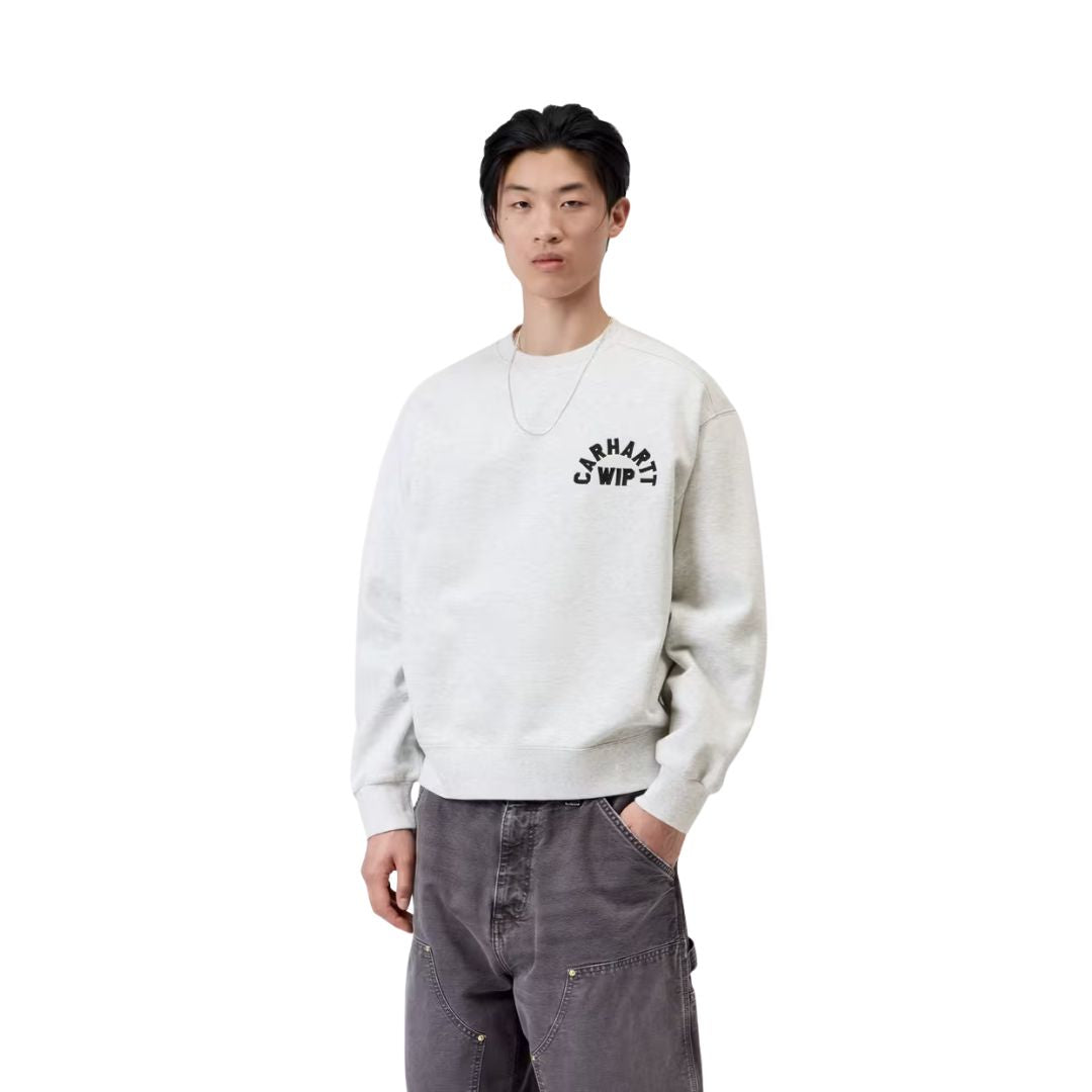Modelo luce de frente la Carhartt WIP Arch Script Sweat en ash heather, primer plano del torso. Se distingue con detalle el aplique bordado en el pecho y el cuello redondo.