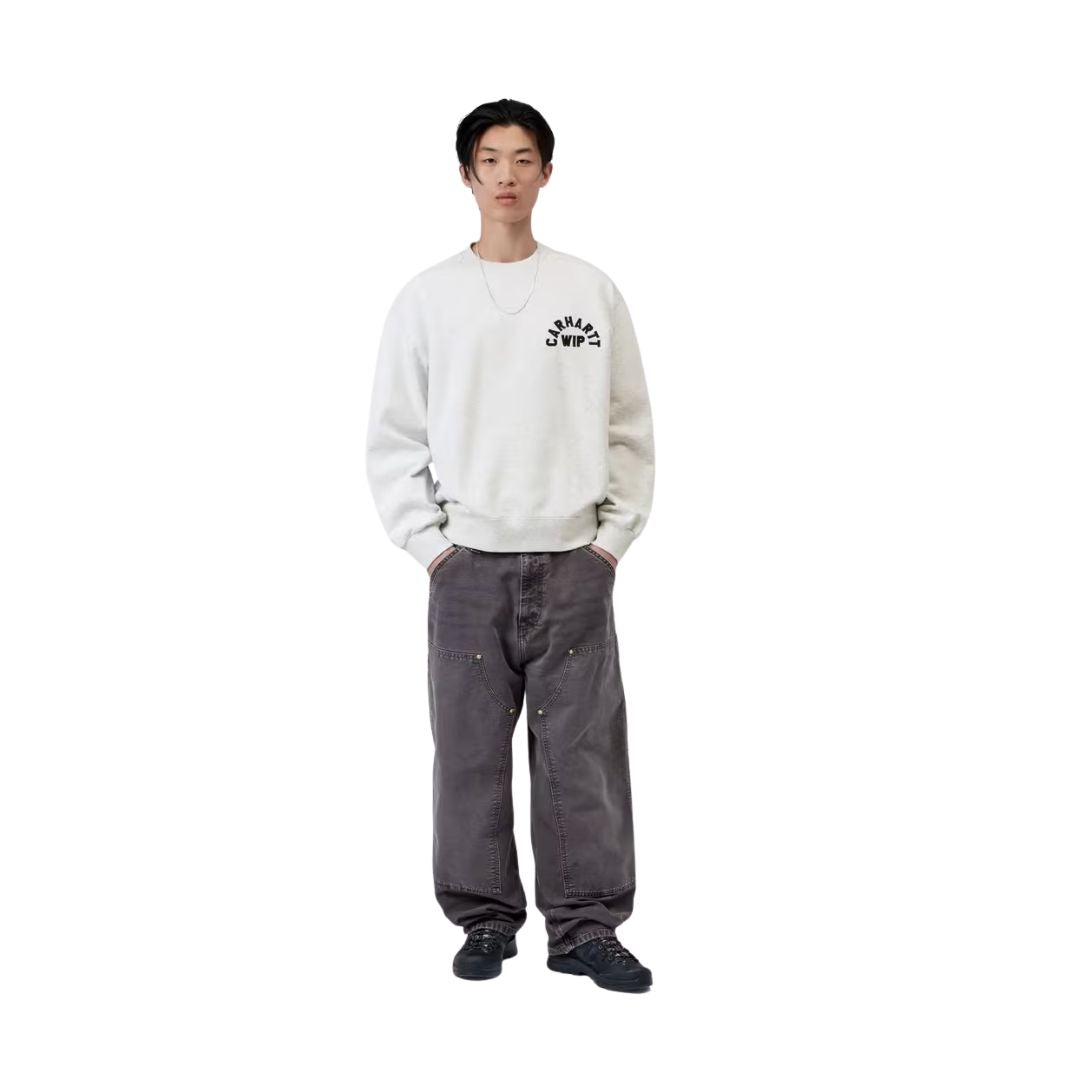 Modelo con Carhartt WIP Arch Script Sweat en ash heather, vista frontal completa. Combina la sudadera de corte globo con pantalón carpenter gris oscuro, mostrando el ajuste holgado.