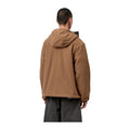Vista trasera de modelo con la chaqueta forro polar ligero Carhartt WIP Blevin Liner en color WIP H Brown, con capucha y corte recto, sobre fondo blanco liso.