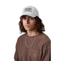 Gorra Carhartt WIP Bumper Sticker Cap en color pontiki, vista frontal en modelo, con bordado de casete 