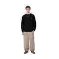 Hombre con el Jersey Carhartt WIP Chane Sweater Negro y pantalones beige