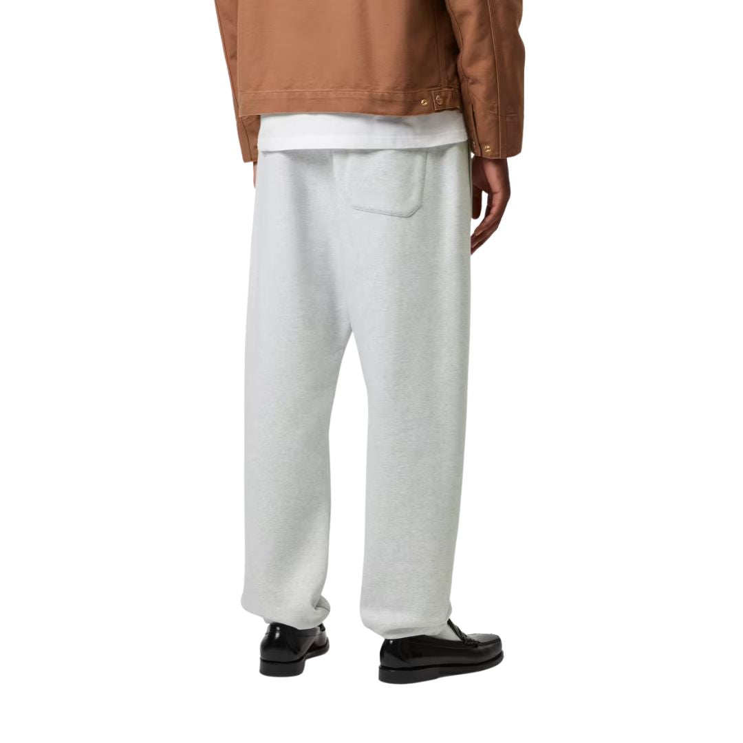 Modelo con Carhartt WIP Chase Sweat Pant en negro, vista trasera. Se aprecia el bolsillo trasero con solapa y la caída holgada del punto cepillado.