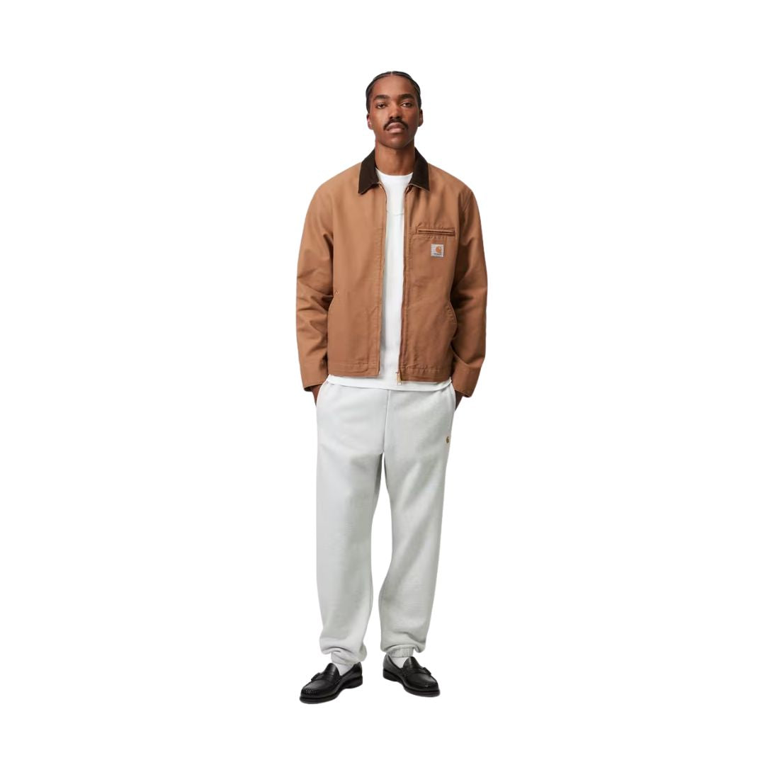 Modelo con Carhartt WIP Chase Sweat Pant en negro, vista frontal completa. Combina el jogger con camiseta blanca, mostrando el corte holgado y la caída del pantalón.