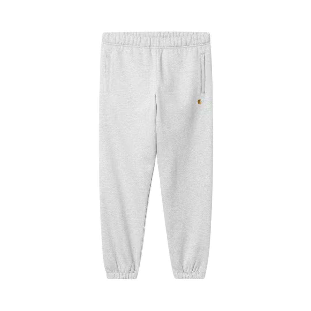 Carhartt WIP Chase Sweat Pant en negro, vista frontal plana sobre fondo blanco. Se aprecia el logo "C" bordado en dorado, los bolsillos frontales y la cintura elástica.