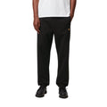 Modelo con Carhartt WIP Chase Sweat Pant en ash heather, primer plano frontal desde la cintura. Muestra la cintura elástica ajustable y el logo 