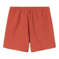 Bañador Carhartt WIP Chase Swim Trunks en color oxide red con detalle gold, vista trasera con bolsillo.