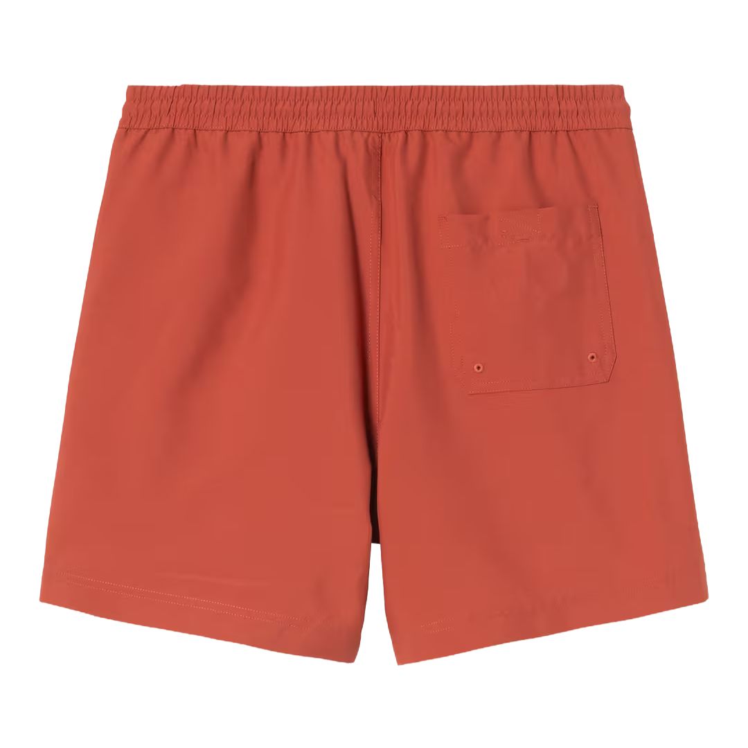 Bañador Carhartt WIP Chase Swim Trunks en color oxide red con detalle gold, vista trasera con bolsillo.