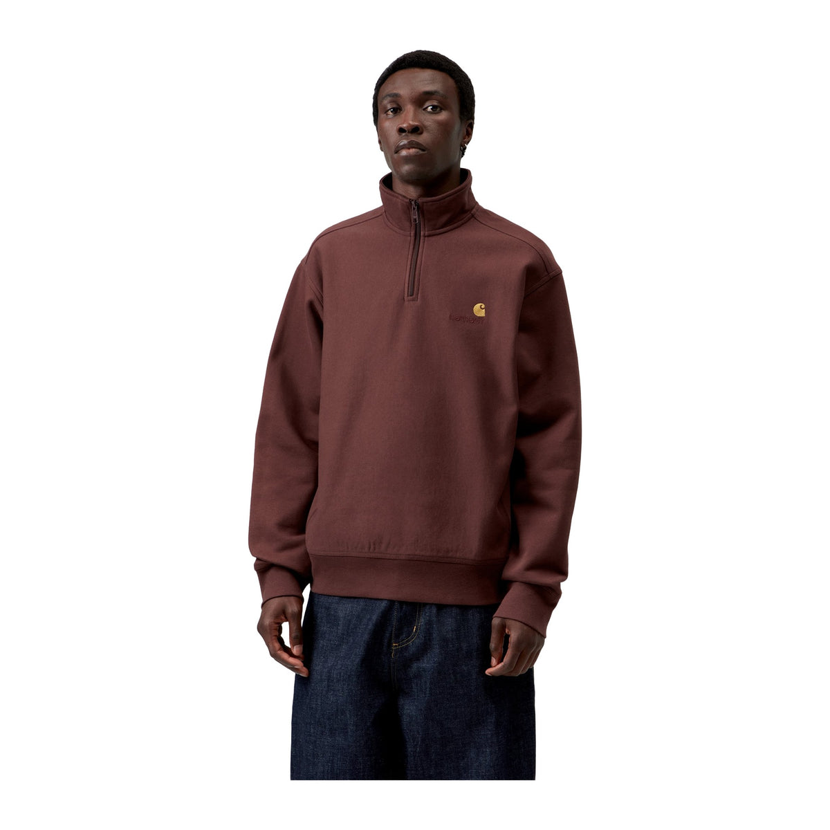 Modelo de frente con la sudadera de cuello alto y media cremallera Carhartt WIP Half Zip American Script Sweat en color Amarone, con el logotipo bordado en el pecho.