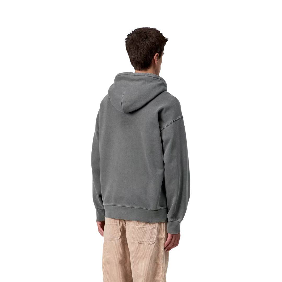 Vista trasera del modelo con la Carhartt WIP Hooded Vista Sweat en color negro garment dyed, mostrando la capucha holgada y las mangas raglán con costuras vistas.