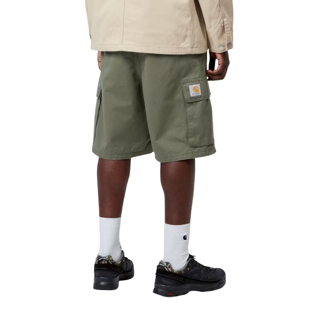 Carhartt WIP Kade Cargo Short Leaf Stone Washed, vista trasera: bolsillos cargo laterales con solapa y etiqueta cuadrada tejida, corte relaxed fit en verde kaki.