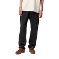 Detalle frontal del pantalón Carhartt WIP Klondike Pant negro stone washed en modelo, corte regular ajustado.