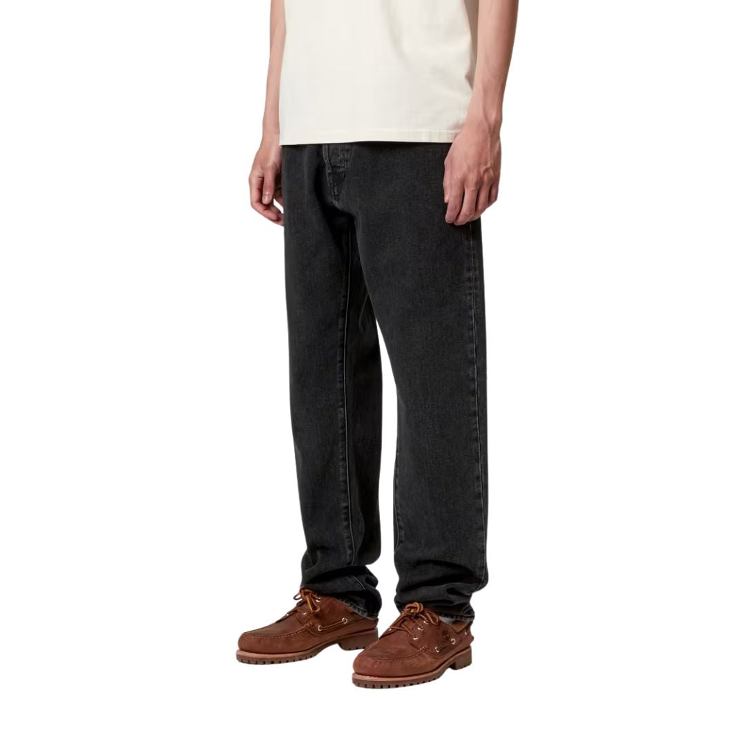 Detalle lateral del pantalón Carhartt WIP Klondike Pant negro stone washed en modelo, ajuste regular ajustado.