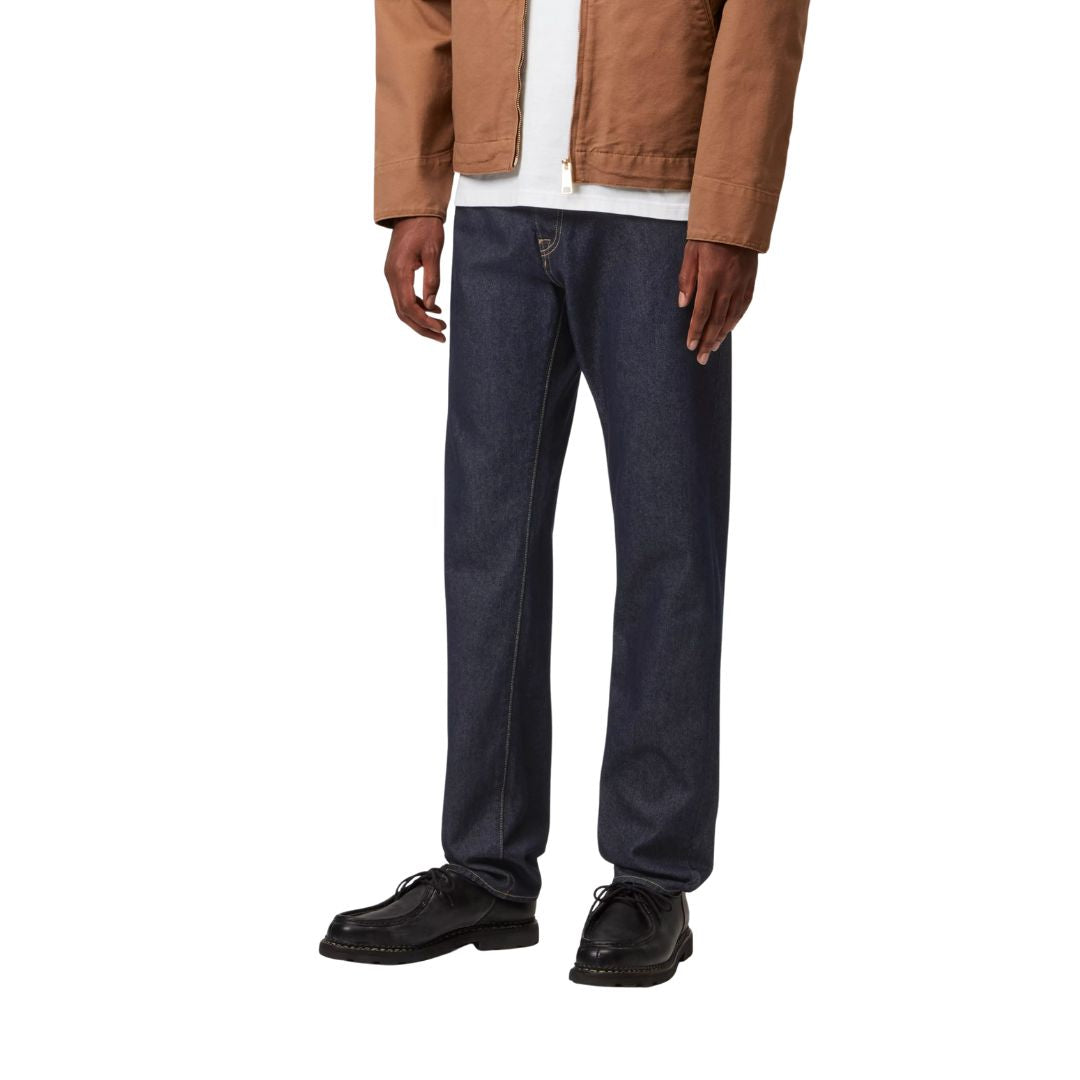 Detalle inferior de pantalón carhartt wip klondike pant azul denim lavado con zapatos negros