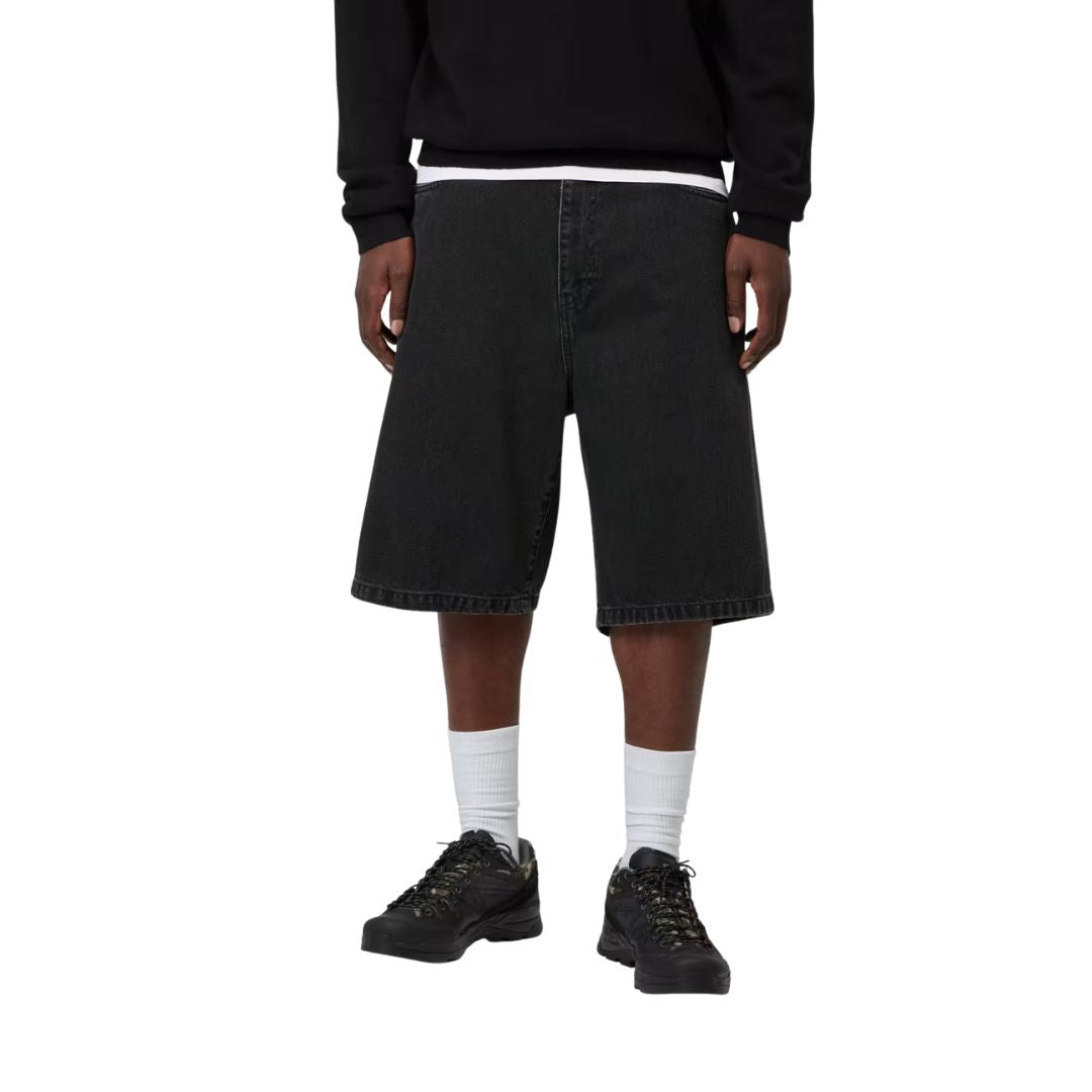 Carhartt WIP Landon Short negro lavado a la piedra, modelo vista frontal cuerpo completo, corte holgado denim negro con matices grises.