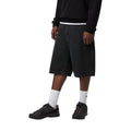 Carhartt WIP Landon Short negro lavado a la piedra, modelo vista lateral frontal, caída holgada y largo hasta rodilla con denim algodón pesado.
