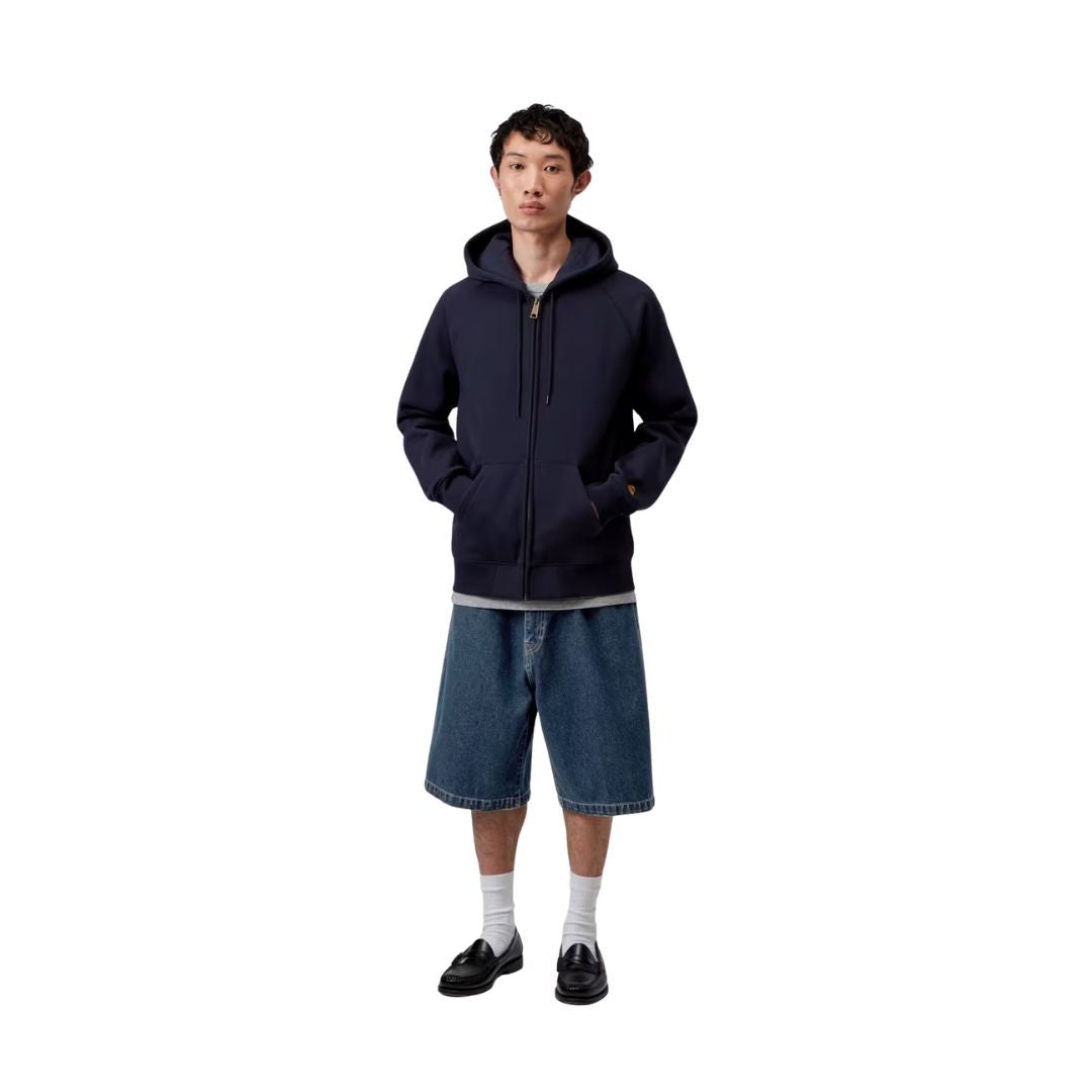 Carhartt WIP Landon Short azul stone washed, modelo vista frontal cuerpo completo, corte holgado cintura regular combinado con sudadera con capucha.