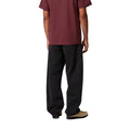 Modelo masculino con pantalón Carhartt WIP Landon Pant negro, vista trasera mostrando ajuste holgado.