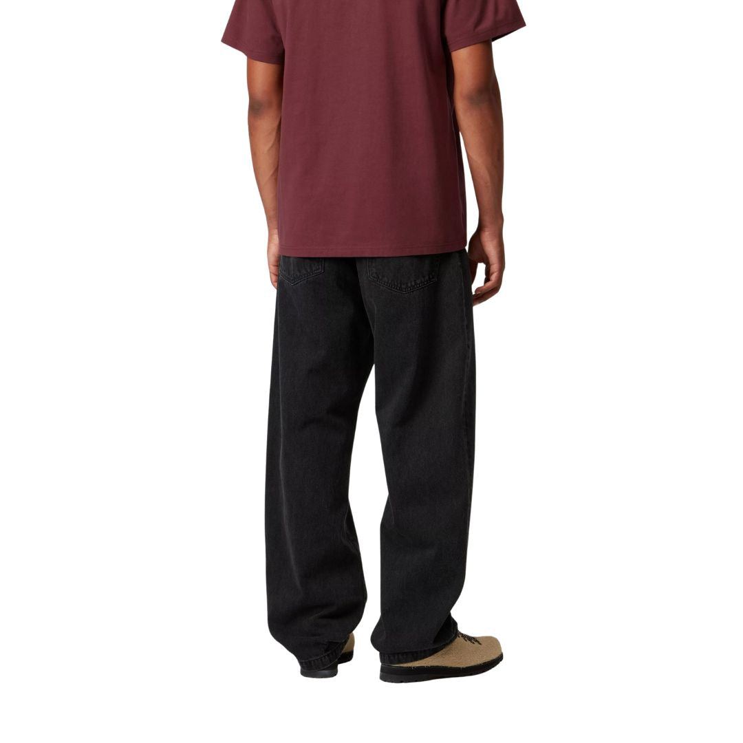 Modelo masculino con pantalón Carhartt WIP Landon Pant negro, vista trasera mostrando ajuste holgado.