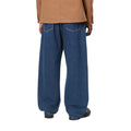 Pantalón vaquero Carhartt WIP Landon azul stone washed, primer plano trasero en modelo mostrando los bolsillos traseros y el estrechamiento bajo la rodilla.